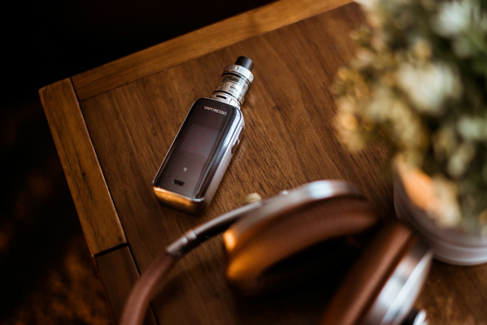 Black box mod pod device resting on a brown wooden table