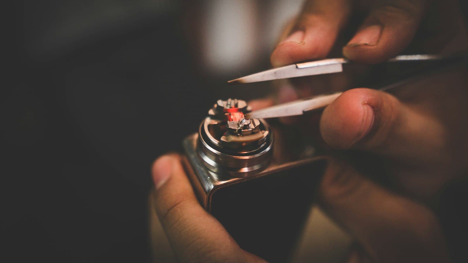 Hands checking a pod is correctly seated into a box mod device